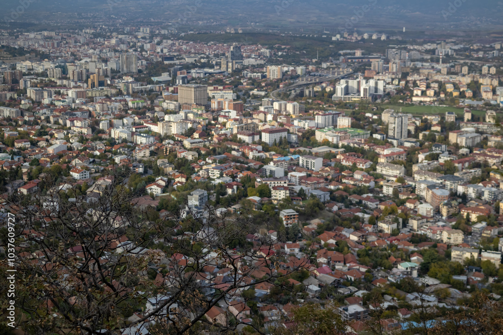 Fototapeta premium Skopje, a thriving urban panorama The city of Skopje, seen from above Aerial view of the Macedonian capital Skopje, a mosaic of colors and shapes where the mountains meet the metropolis.