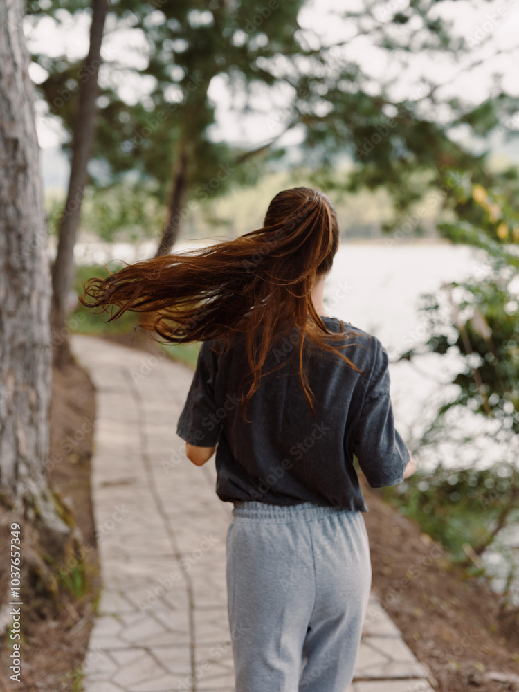Thoughtful young woman walking along a serene pathway by a tranquil lake, enjoying nature and reflecting on life Peaceful and mindful outdoor journey concept Thoughtful young woman walking along a serene pathway by a tranquil lake, enjoying nature and reflecting on life Peaceful and mindful outdoor journey concept