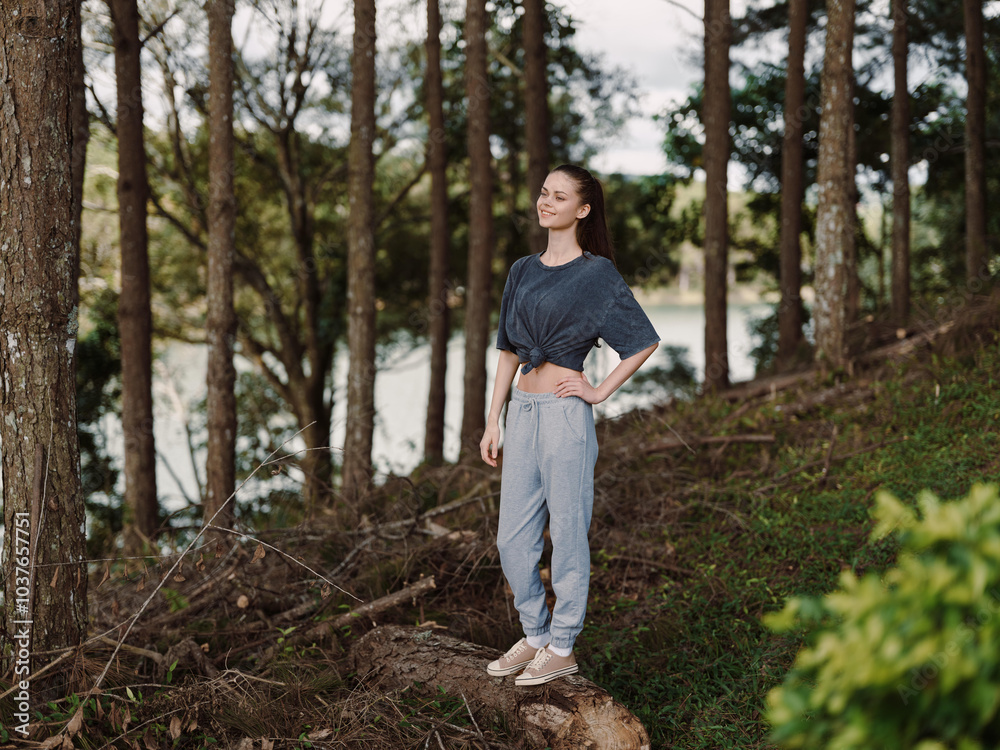 Confident young woman standing in a serene forest setting, wearing casual clothing and enjoying nature, embodying a sense of peace and self assurance Confident young woman standing in a serene forest setting, wearing casual clothing and enjoying nature, embodying a sense of peace and self assurance