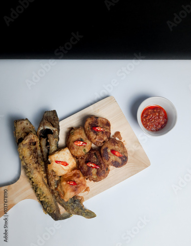 Perkedel, lele goreng or fried catfish, and fried tofu with sauce or chili paste (sambal). Indonesian fried patties photo