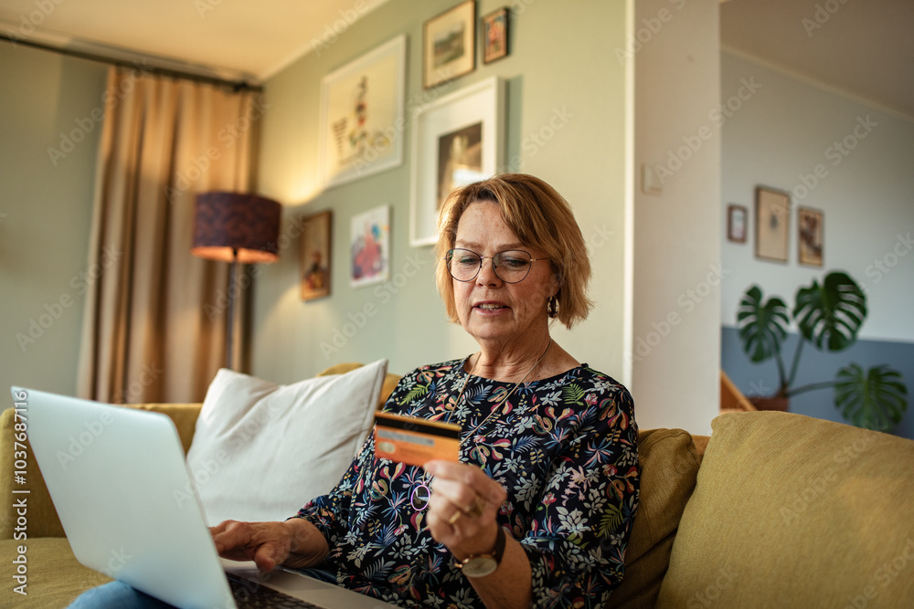 Senior woman holding credit card online shopping at home with laptop Senior woman holding credit card online shopping at home with laptop