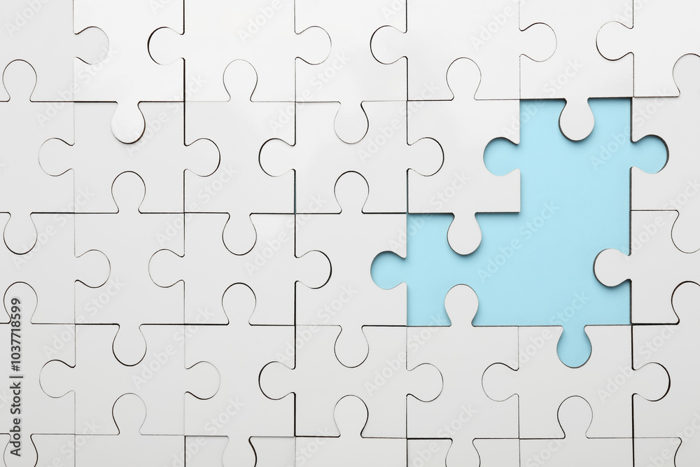 White puzzle with missing pieces on light blue background, top view White puzzle with missing pieces on light blue background, top view