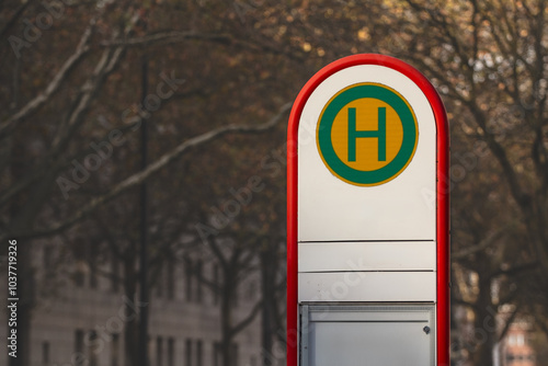 Selective blur on a typical austrian and german bus stop sign, called haltestelle, or bushaltestelle, in a dortmund urban environment. it indicates the presence of a public transportation stop station photo