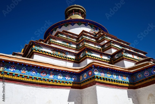 Witness the Palcho Monastery in Gyantse, Tibet, a 14th-century Buddhist temple celebrated for its vivid murals, multi-tiered roof, and exquisite carvings, all framed by a stunning backdrop of blue sky photo