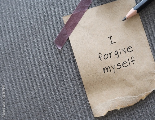 Brown paper on wallpaper with message text I FORGIVE MYSELF, positive affirmation of learning to fully accept whatever you did - forgive and let go any resentment you have made significant mistakes