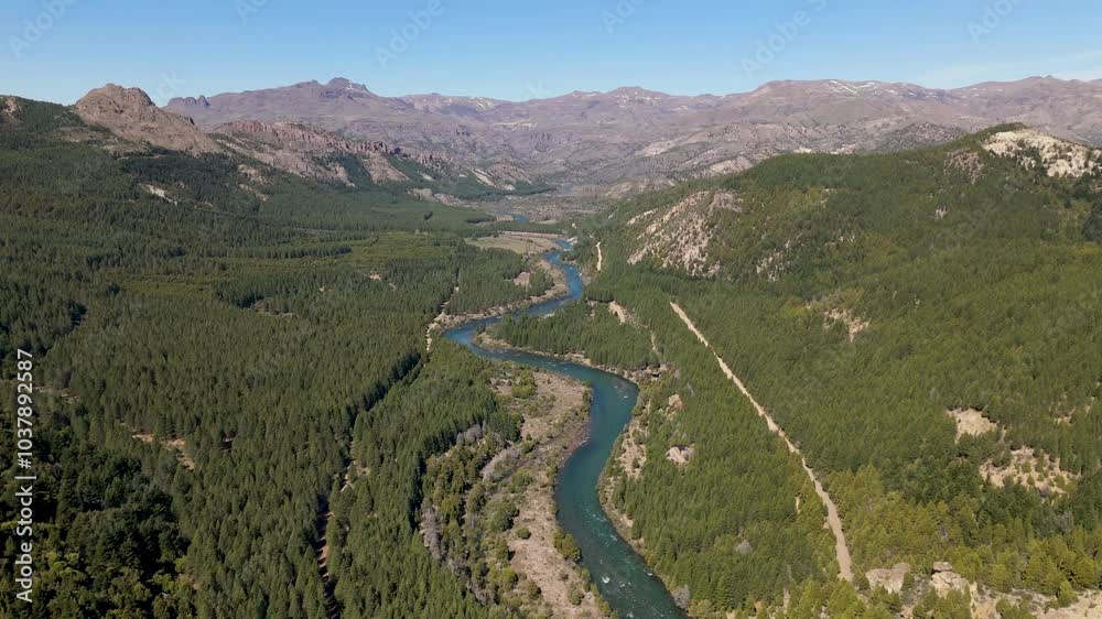 Aerial shot of the Caleufú River winding through the lush pine forests in Villa Meliquina, Argentina. The landscape is dominated by vast green forests, including pines, coihue, and lenga trees. Aerial shot of the Caleufú River winding through the lush pine forests in Villa Meliquina, Argentina. The landscape is dominated by vast green forests, including pines, coihue, and lenga trees.