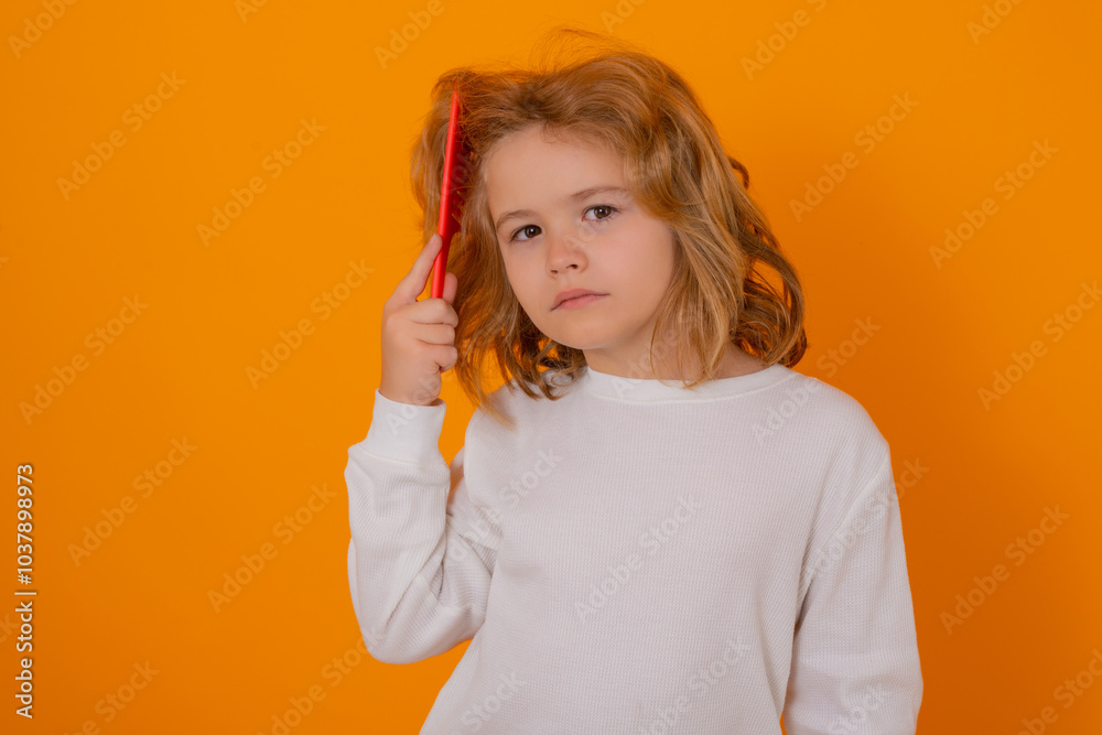 Portrait of child combing hair with comb on yellow studio background. Conditioner and shampoo for kids hair. Portrait of child combing hair with comb on yellow studio background. Conditioner and shampoo for kids hair.