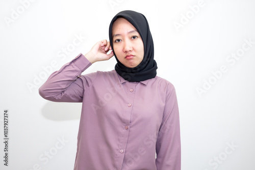 portrait of Asian, Indonesian woman wearing shirt and hijab yawning and stretching her hands. Lazy woman who looks sleepy, bored and tired. Isolated on white background