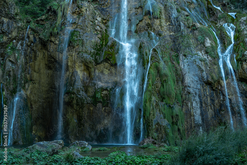 Fototapeta premium Beauty Waterfall in the Plitvice Lakes in Croatia. The waterfalls in forest. Summer view of beautiful waterfalls and clear lake. Plitvice Lakes National Park, Croatia. Summer nature landscape.