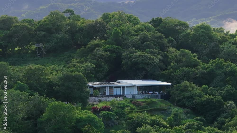 An elegantly designed house in the vibrant forests of Costa Rica, captured aerially. It perfectly blends nature and contemporary architecture, showcasing modern living coexisting with nature An elegantly designed house in the vibrant forests of Costa Rica, captured aerially. It perfectly blends nature and contemporary architecture, showcasing modern living coexisting with nature