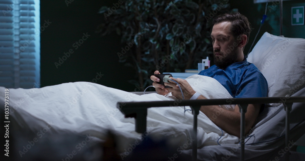 Fototapeta premium Sick person in bed with a phone, playing games winning.
