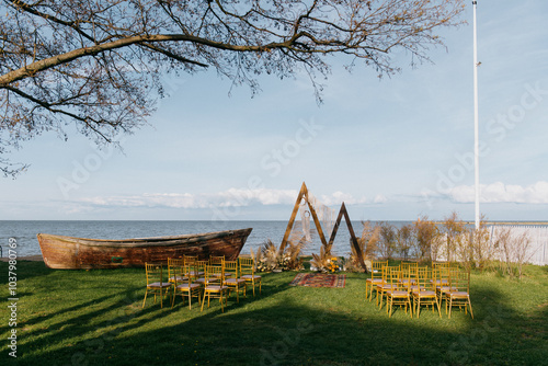 A beautiful wedding ceremony is currently taking place in front of the vast ocean, with a charming boat visible in the background