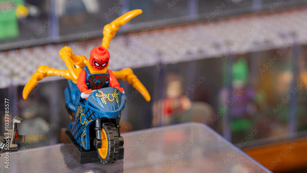 Naklejka premium Budokan Geek Convention In GUAYAQUIL, ECUADOR - OCT 13, 2024 - Spider-Man action figure riding a motorcycle with golden spider legs at a toy display event.