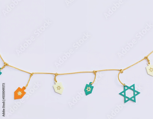 a Hanukkah garland with star of David icons on dreidels hanging from the string on lilac background