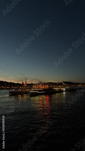 Barcos a través de un río se iluminan de noche