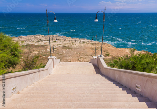 Fototapeta Naklejka Na Ścianę i Meble -  Stairs at Polignano a mare in Puglia, Italy, Beach of Cala Paura in Puglia, Adriatic Sea., Lama Monachile beach, Polignano a Mare, Apulia, Italy, province of Bari.