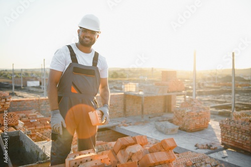 Indian Construction worker in uniform and safety equipment have job on building photo