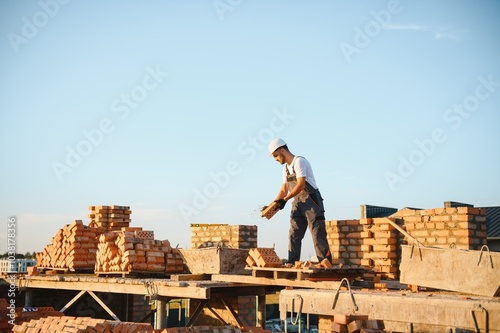 Construction worker in uniform and safety equipment have job on building