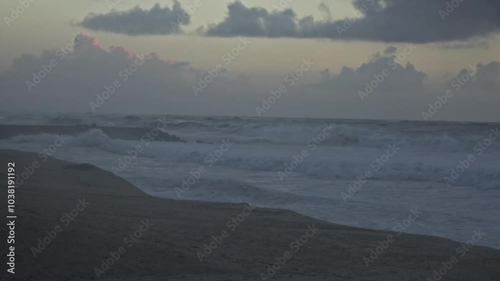 As storm clouds gather at sunset, massive ocean waves crash against the shore, creating a dramatic and turbulent scene. The churning water and dark sky capture the raw power of nature. As storm clouds gather at sunset, massive ocean waves crash against the shore, creating a dramatic and turbulent scene. The churning water and dark sky capture the raw power of nature.