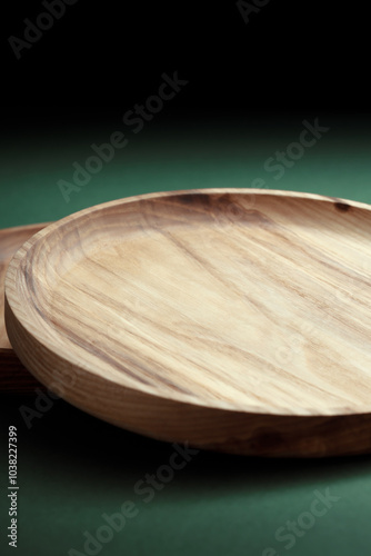 Wooden flat plates on a green background. The concept of ecological tableware. Products for modern kitchen. Zero emissions. photo