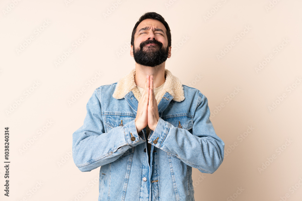 Fototapeta premium Caucasian man with beard over isolated background keeps palm together. Person asks for something