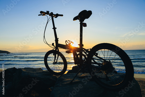 A folding bike on sunrise seaside rocka photo