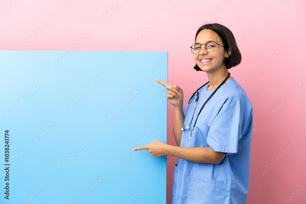 Young mixed race surgeon woman with a big banner over isolated background pointing finger to the side and presenting a product Young mixed race surgeon woman with a big banner over isolated background pointing finger to the side and presenting a product