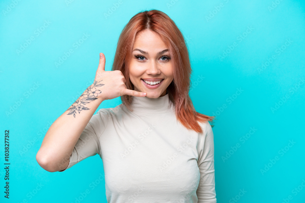 Fototapeta premium Young Russian woman isolated on blue background making phone gesture. Call me back sign
