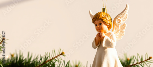 white porcelain angel ornament hanging against a beige background photo