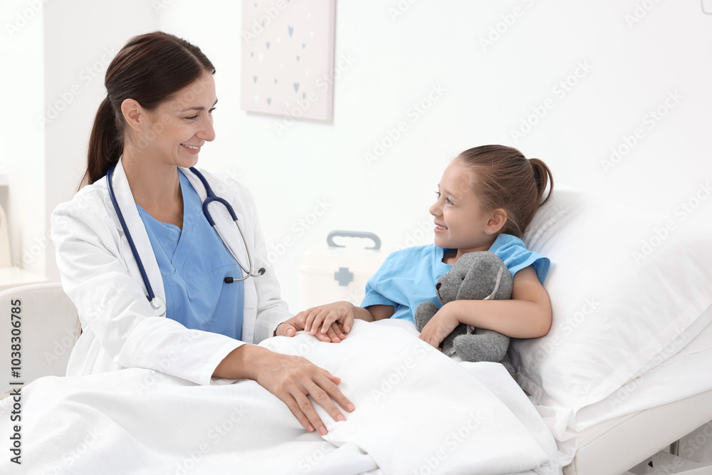 Doctor examining little girl on bed at hospital Doctor examining little girl on bed at hospital