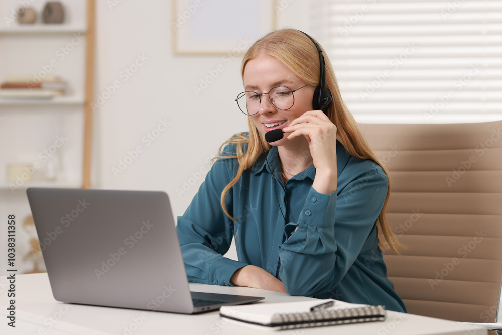 Interpreter in headset working with laptop at table indoors Interpreter in headset working with laptop at table indoors