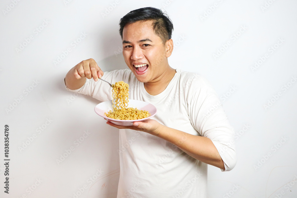 Asian Man grasping and lifting up Noodles Hungrily from Bowl using fork. Craving Satisfied: Hungry Asian Man Devours Delicious Noodles Asian Man grasping and lifting up Noodles Hungrily from Bowl using fork. Craving Satisfied: Hungry Asian Man Devours Delicious Noodles