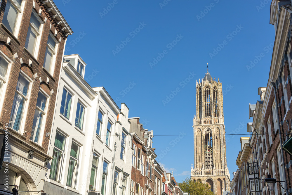 Dom cathedral in Utrecht above a row of historical houses against a blue sky