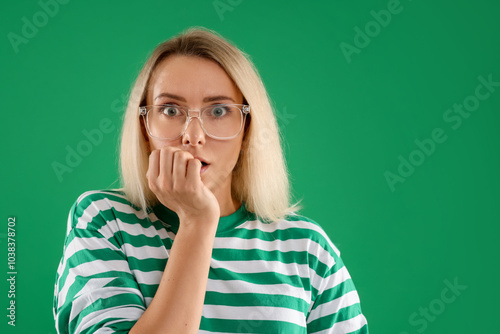 Portrait of scared woman on green background, space for text