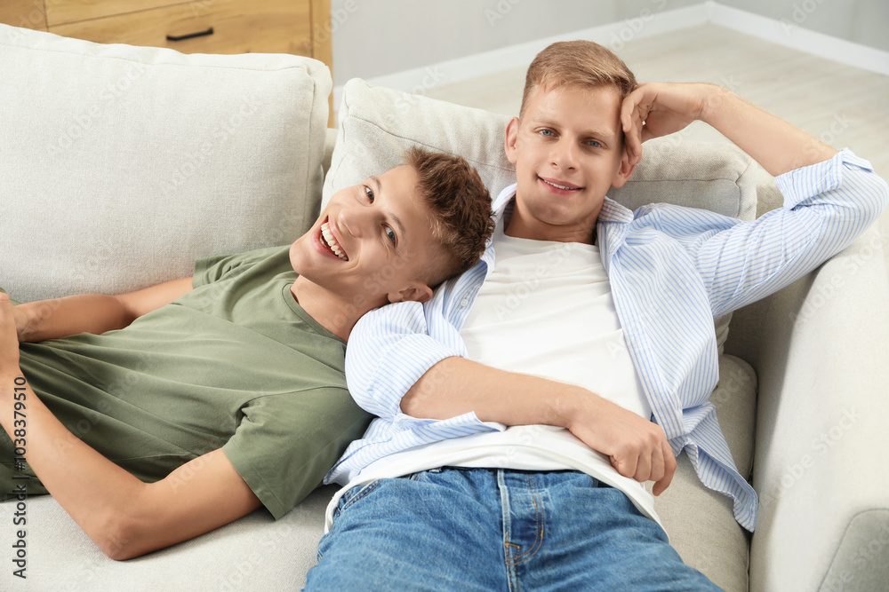 Happy brothers chilling on sofa at home Happy brothers chilling on sofa at home