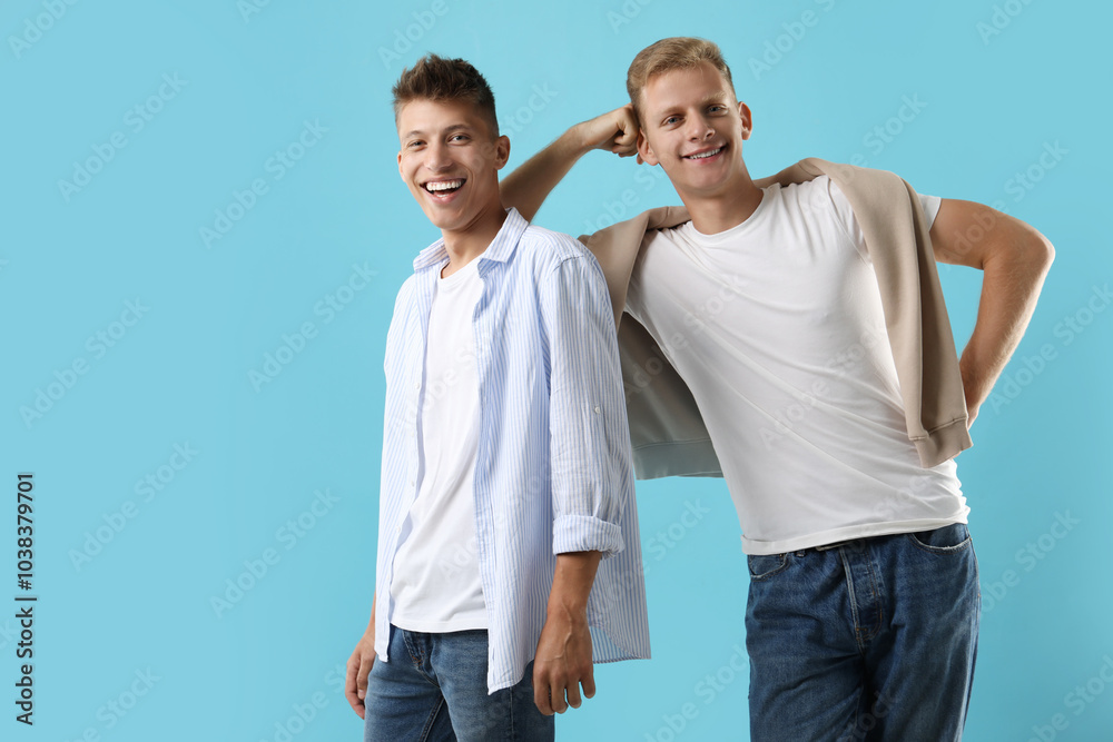 Happy brothers posing on light blue background. Space for text Happy brothers posing on light blue background. Space for text