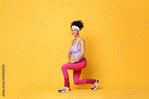 Happy woman doing aerobic exercise on orange background