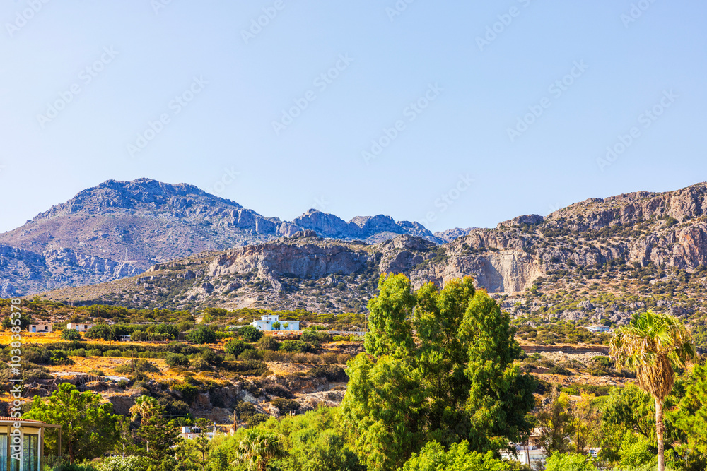 Mountain landscape with rocky cliffs and green trees under bright blue sky in sunny weather. Crete. Greece. Mountain landscape with rocky cliffs and green trees under bright blue sky in sunny weather. Crete. Greece.