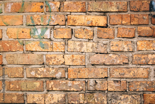 Old grungy brick wall. Free space for an inscription. Can be used as a background or poster. Fragment of a wall with bumps and shabby plaster.