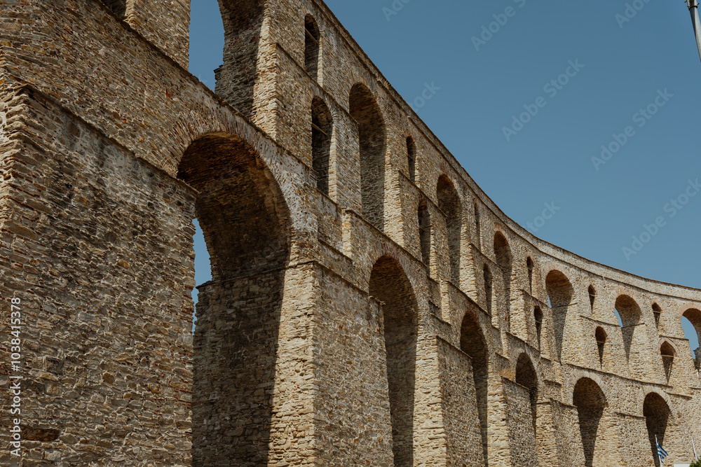 Cityscape with medieval aqueduct Kamares in the Kavala city. Sunny summer day in the Macedonia, Greece, Europe. Cityscape with medieval aqueduct Kamares in the Kavala city. Sunny summer day in the Macedonia, Greece, Europe.