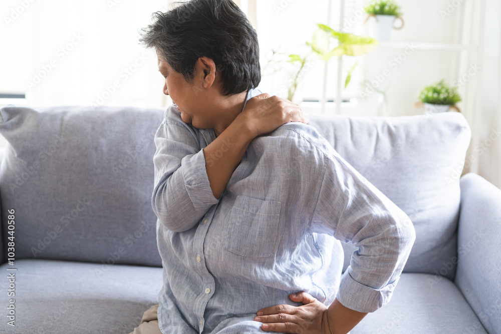 Pain body muscles stiff problem, suffer asian senior woman painful, older hand holding neck ache and aged holding massaging rubbing body, injury hurt,sore sitting on sofa at home. Health care concept. Pain body muscles stiff problem, suffer asian senior woman painful, older hand holding neck ache and aged holding massaging rubbing body, injury hurt,sore sitting on sofa at home. Health care concept.