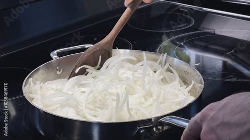 Cooking Onions in a Pan with a Wooden Spoon