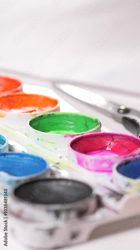 vertical video little girl dipping brush picking up pink paint from a palette