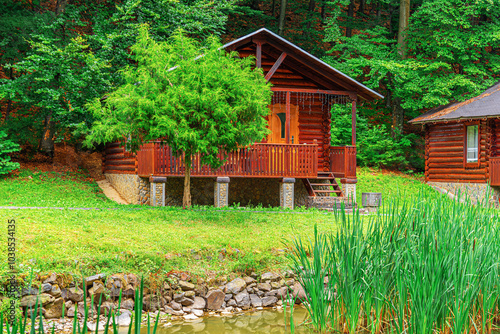 Obraz na płótnie Wooden house in green forest in summer day. w salonie