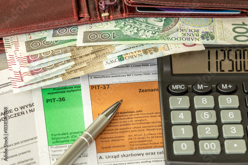 Income tax settlement in Poland. Financial concept. Tax form pit37, pit36, Wallet with Polish money and tax calculation on calculator. close up