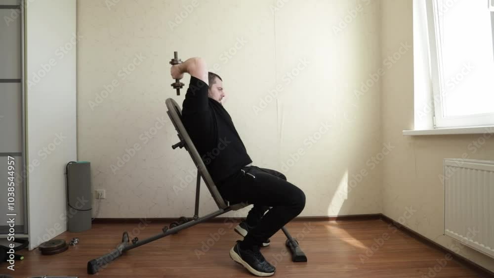 Man exercising in home gym, committed to regular strength training, staying active and strong with a disciplined routine. Man exercising in home gym, committed to regular strength training, staying active and strong with a disciplined routine.