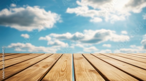 Wooden table top with smooth finish, empty space ready for product display, blurred blue sky and clouds in background.