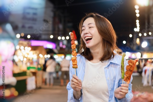 Photography Happy Asian woman eating street food at local market.