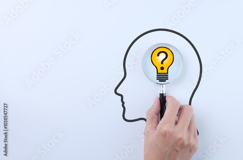 Idea discovery and inquiry concept. Hand holding a magnifying glass over question marks with light bulb, symbolizing idea discovery. Problem solving, Creative thinking, Company find business solution,