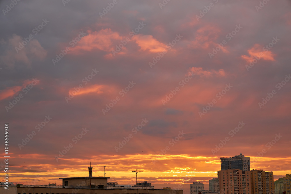 Fototapeta premium Silhouettes of Buildings Against a Fiery Sunset